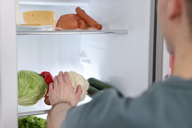 Man taking cauliflower out of refrigerator, closeup