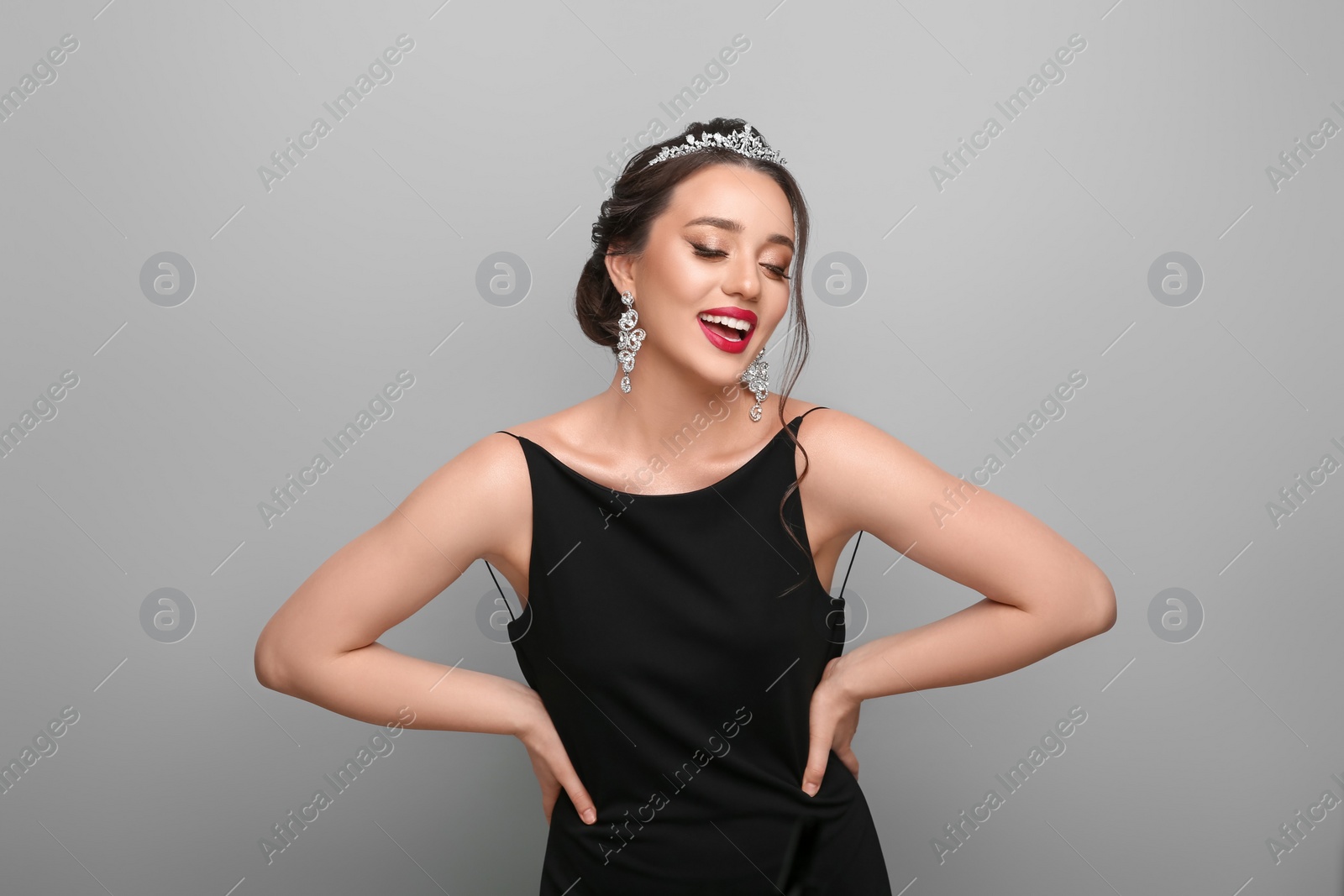Photo of Beautiful young woman wearing luxurious tiara on light grey background