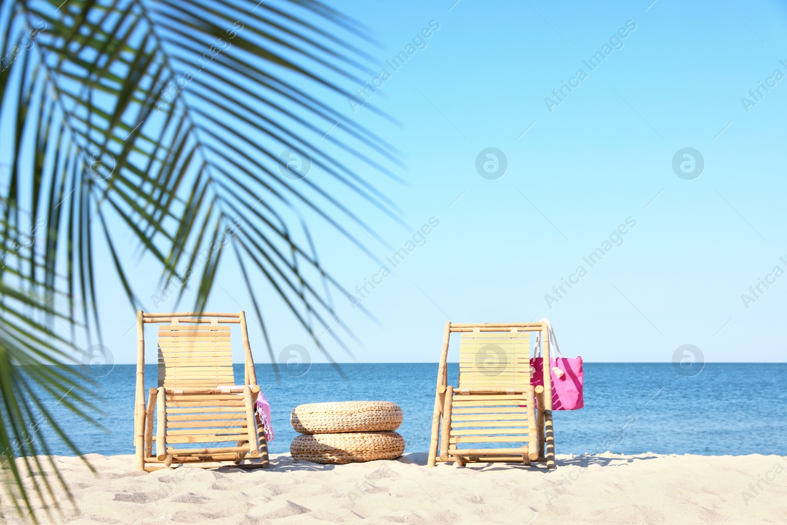 Photo of Wooden sunbeds and beach accessories on sandy shore