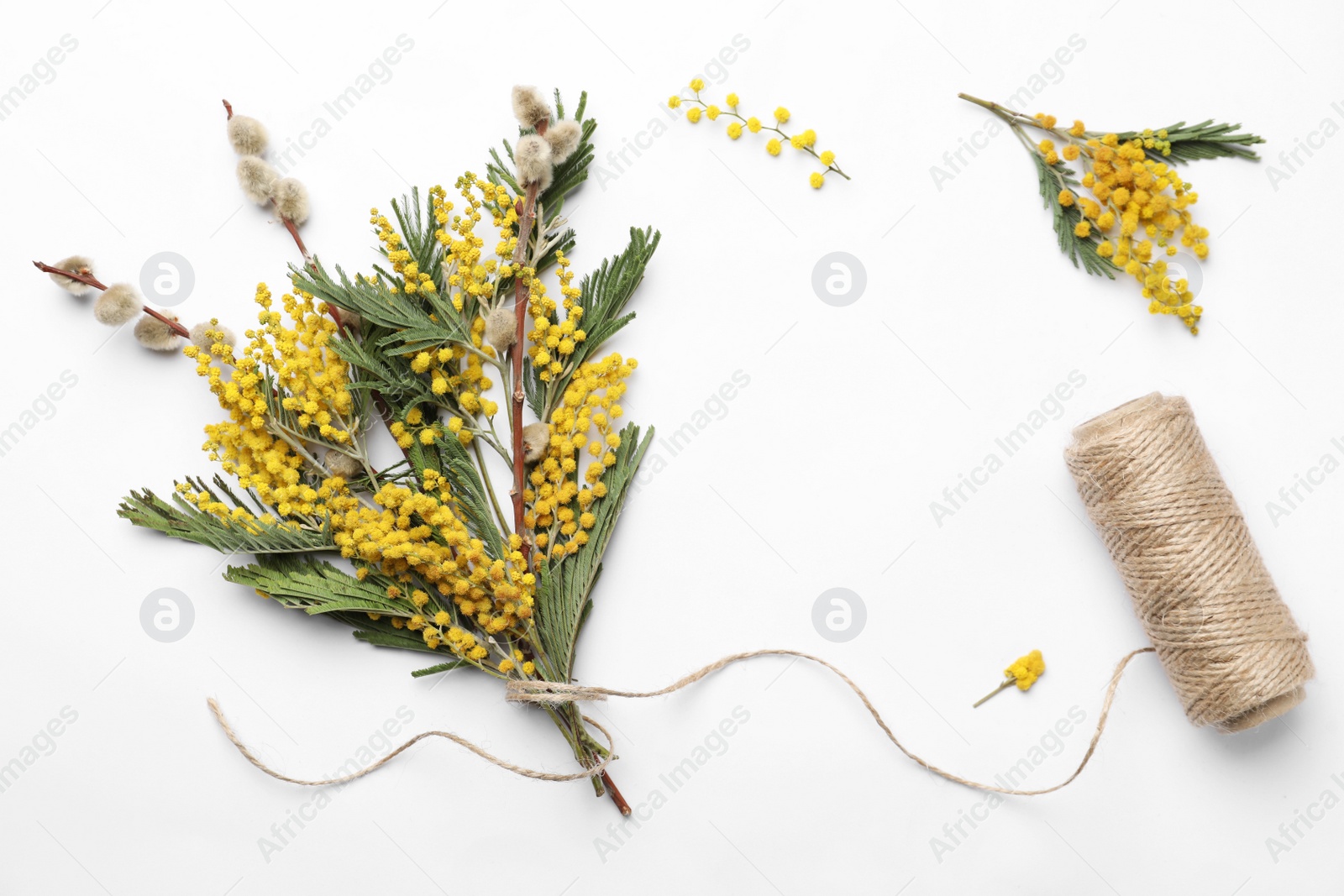 Photo of Beautiful mimosa bouquet and twine on white background, flat lay