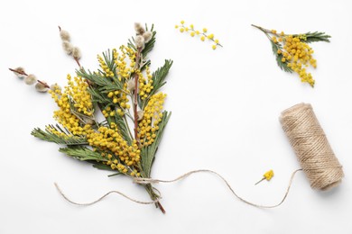 Photo of Beautiful mimosa bouquet and twine on white background, flat lay