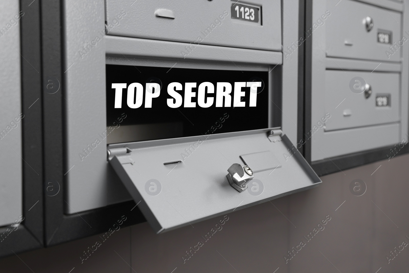 Image of Top Secret stamp. Open metal mailbox indoors