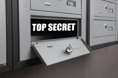 Image of Top Secret stamp. Open metal mailbox indoors