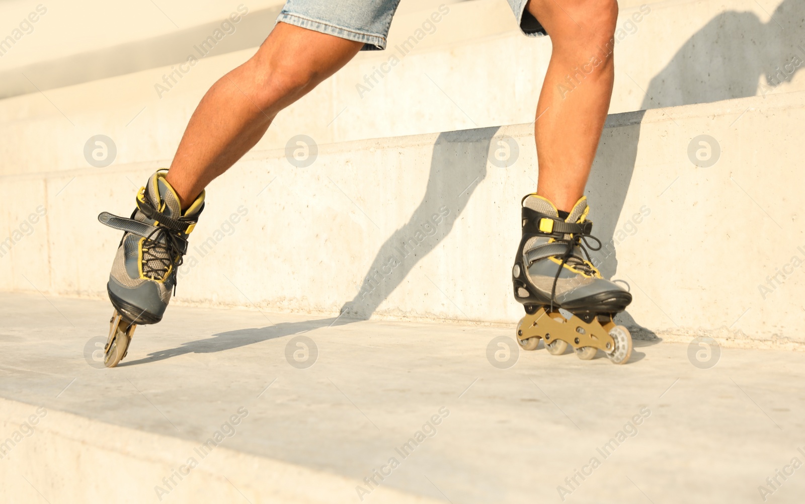 Photo of Young man roller skating outdoors, closeup view