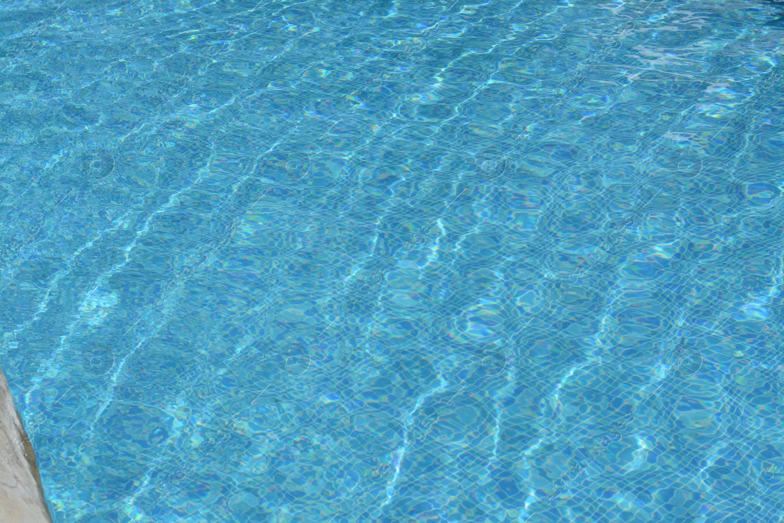 Photo of Clear refreshing water in swimming pool on sunny day, closeup