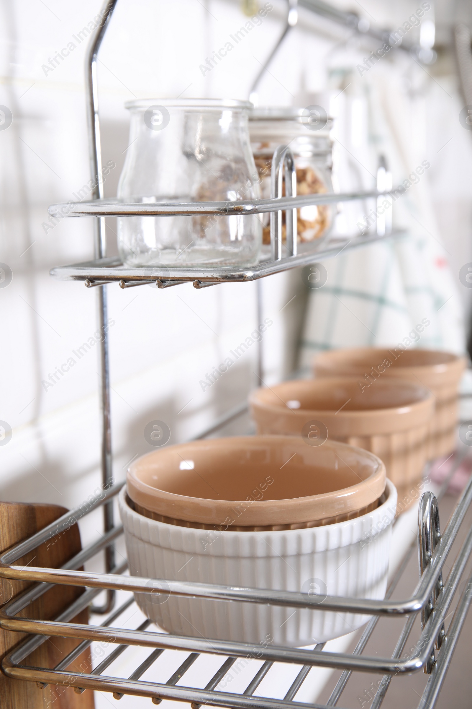 Photo of Many different ramekins on metal rack in kitchen