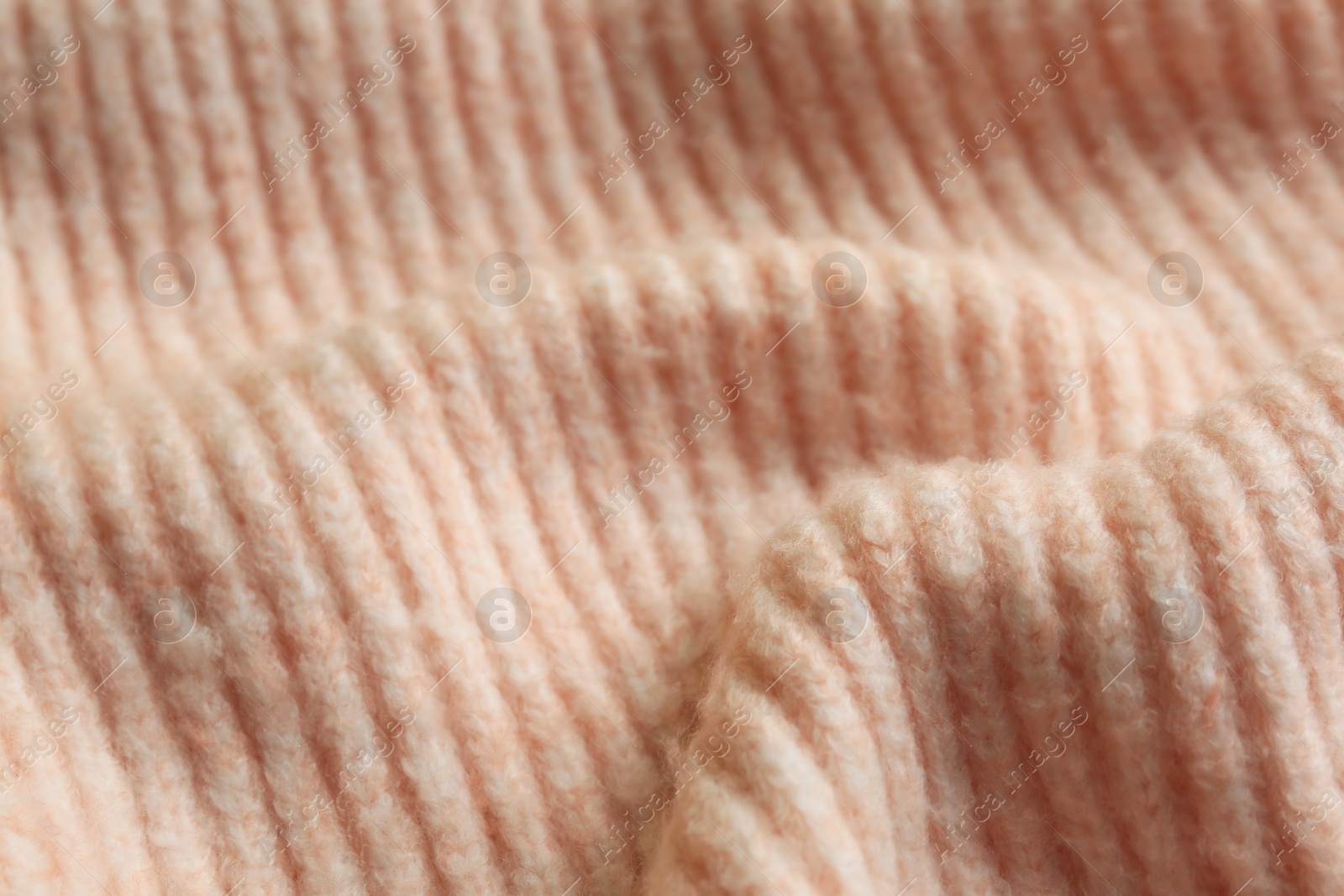 Photo of Beautiful pale pink knitted fabric as background, closeup