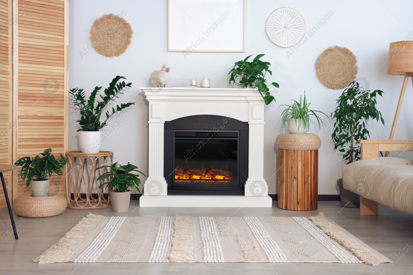 Photo of Beautiful living room interior with fireplace, green houseplants and comfortable sofa