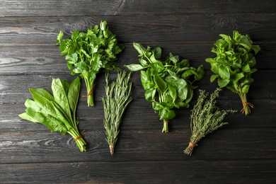 Different fresh herbs on wooden table, top view