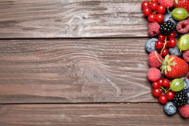 Photo of Different fresh berries on wooden table, flat lay. Space for text