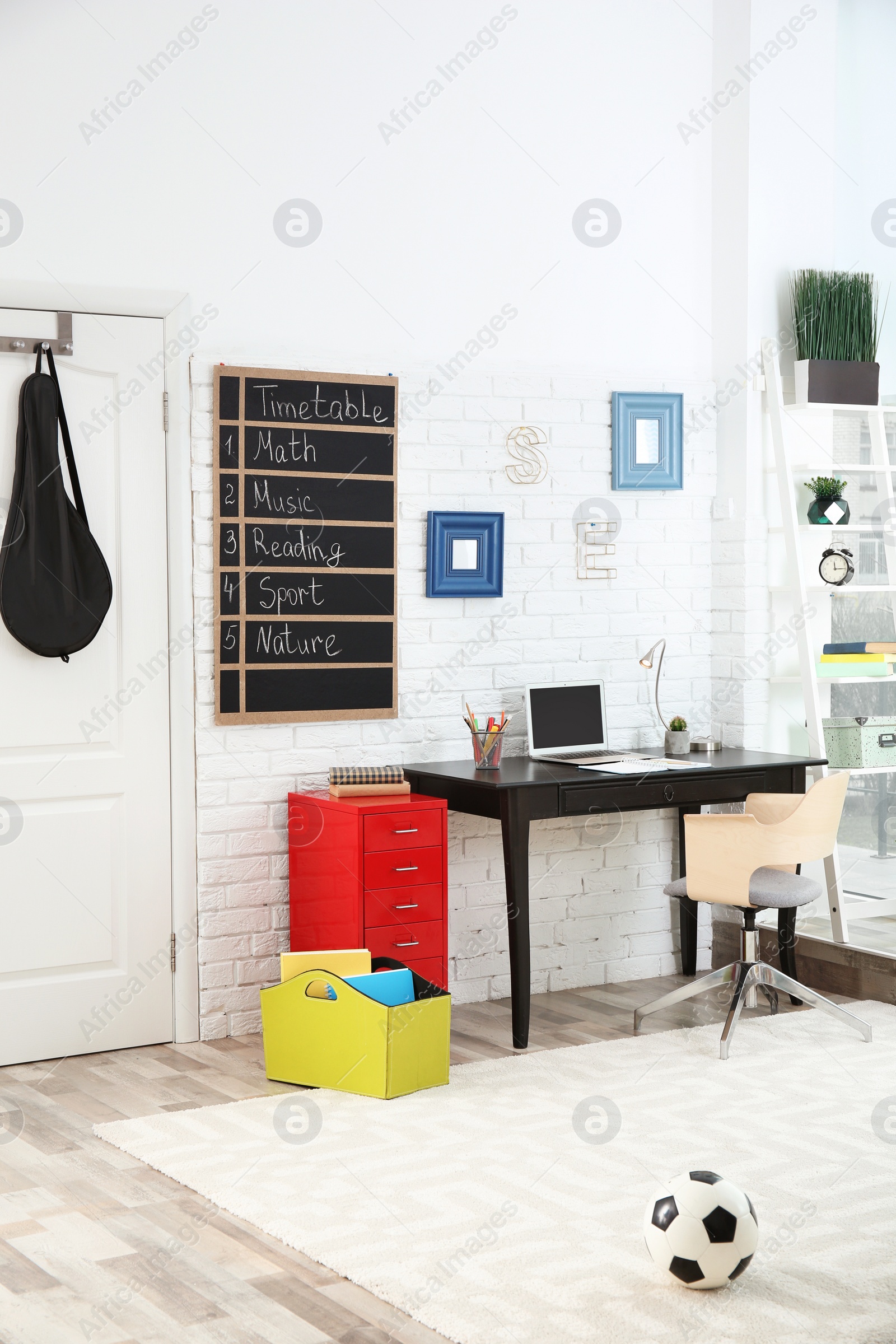 Photo of Modern child room interior with desk and laptop