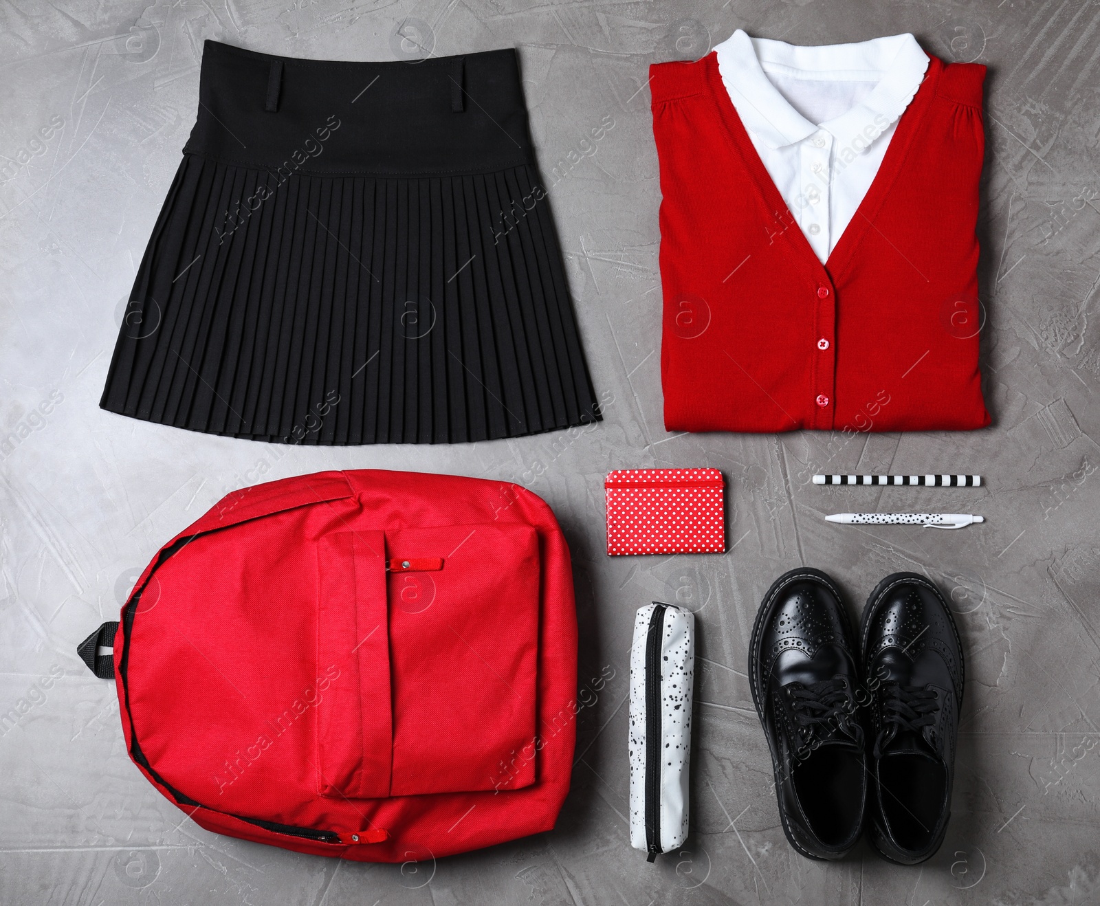 Photo of Flat lay composition with school uniform on grey stone background