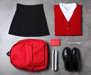 Photo of Flat lay composition with school uniform on grey stone background