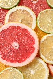 Photo of Different sliced citrus fruits as background, top view