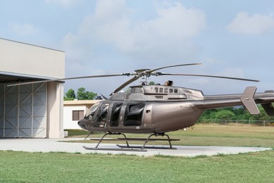 Beautiful helicopter on helipad in field near hangar