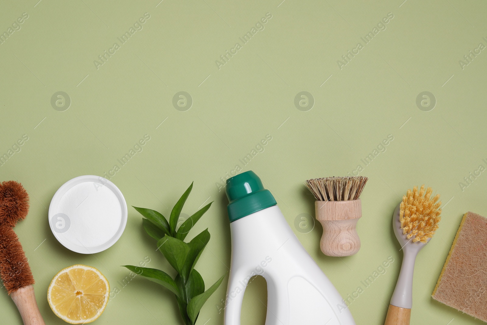 Photo of Flat lay composition with different cleaning supplies on green background, space for text