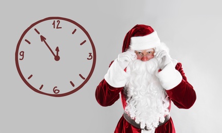 Image of Christmas countdown. Clock showing five minutes to midnight near Santa Claus on light background