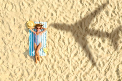 Shadow of airplane and woman sunbathing at sandy beach, aerial view. Summer vacation