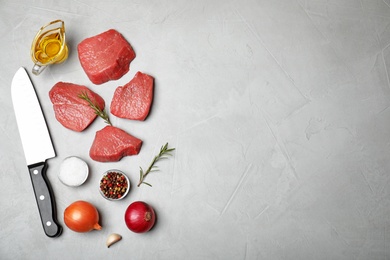 Photo of Flat lay composition with fresh raw meat, products and space for text on gray background