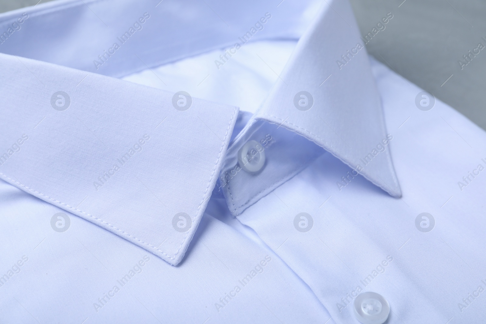 Photo of Closeup view of stylish white shirt. Dry-cleaning service