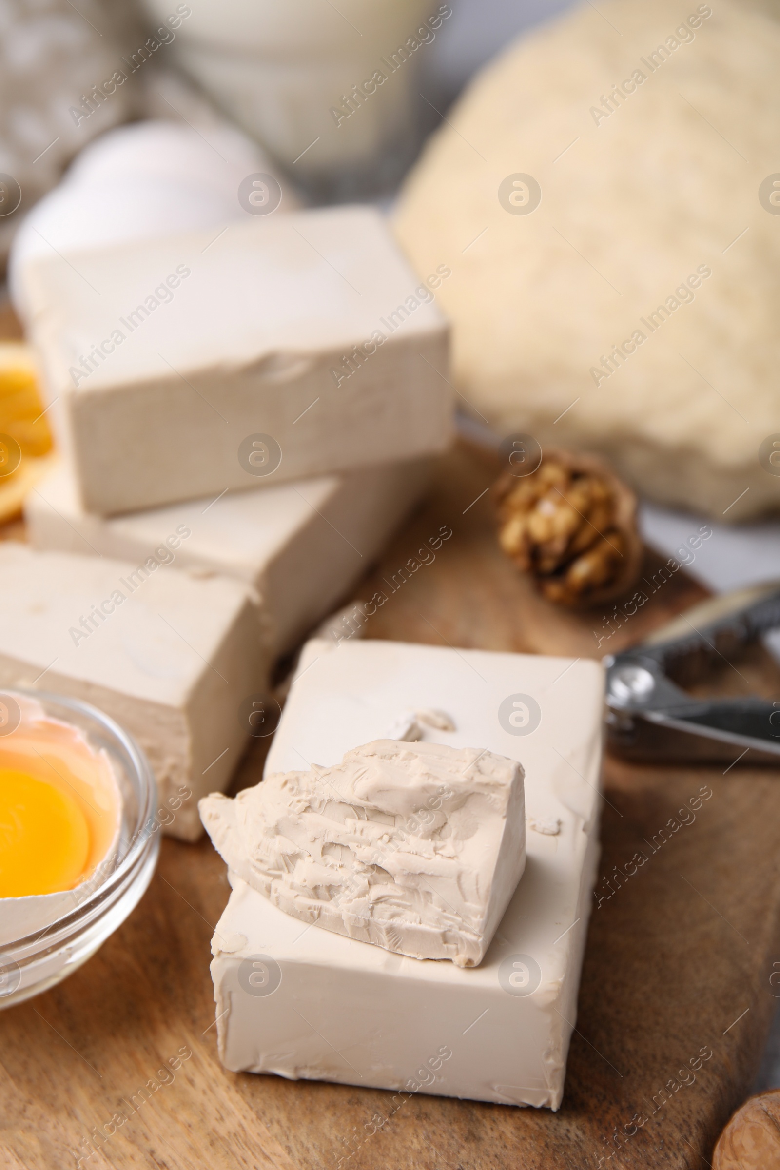 Photo of Blocks of compressed yeast and ingredients for dough on wooden table