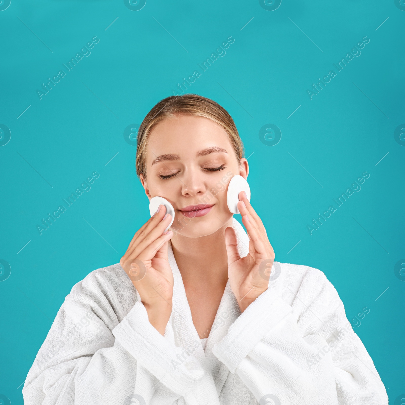 Photo of Beautiful young woman with cotton pads on turquoise background