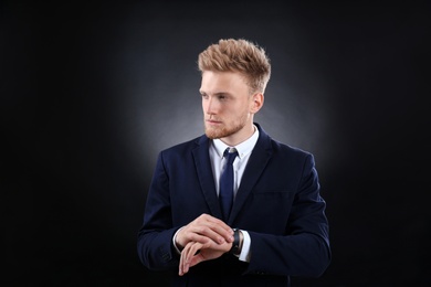 Photo of Portrait of handsome young businessman on dark background