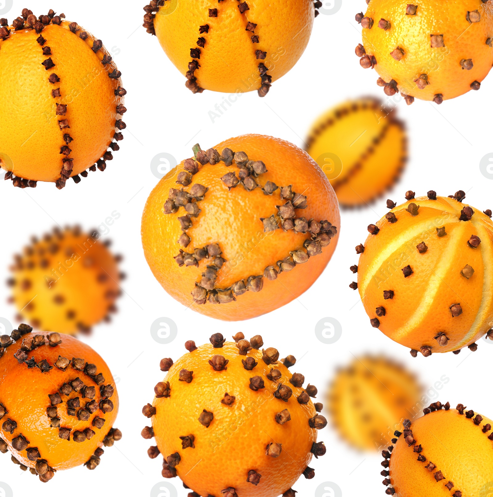 Image of Different pomander balls made of fresh tangerines and cloves falling on white background
