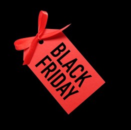 Image of Red tag with phrase BLACK FRIDAY on dark background, top view