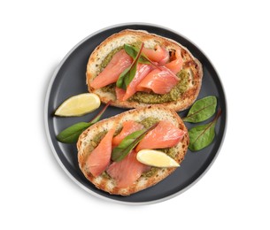 Delicious bruschettas with salmon and pesto sauce on white background, top view