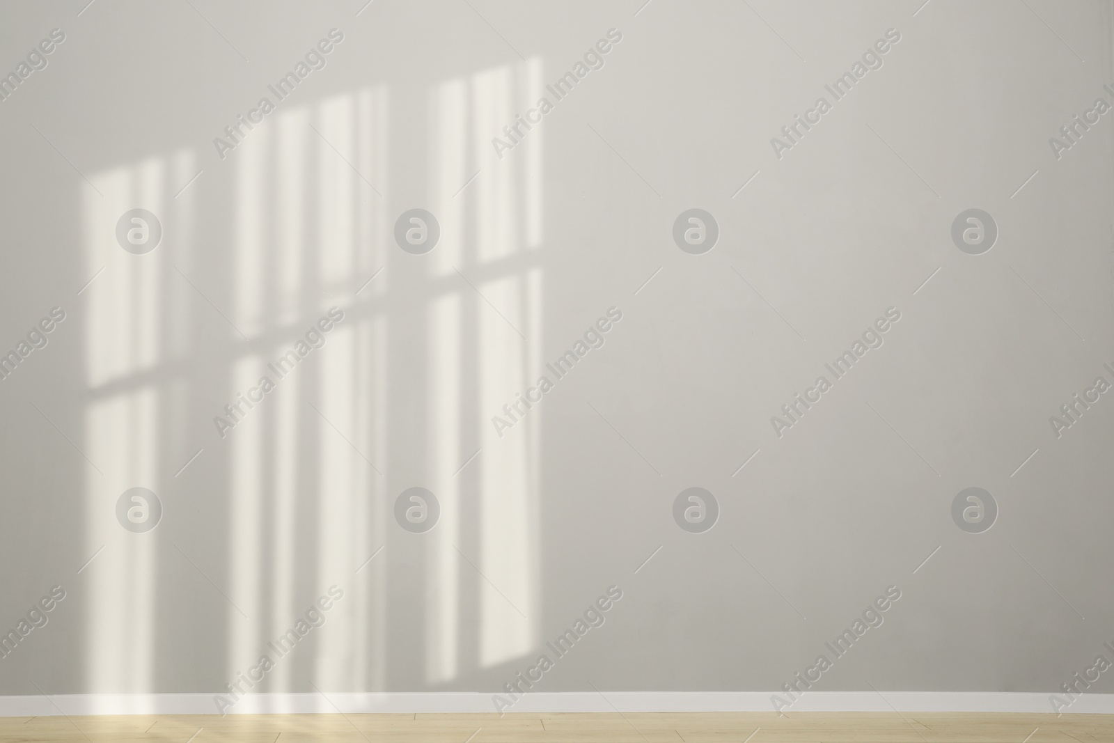 Photo of Light and shadows from window on wall indoors