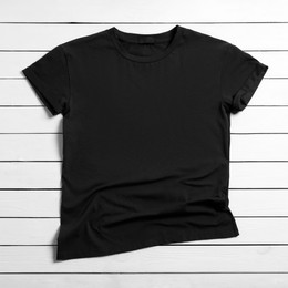 Stylish black t-shirt on white wooden background, top view