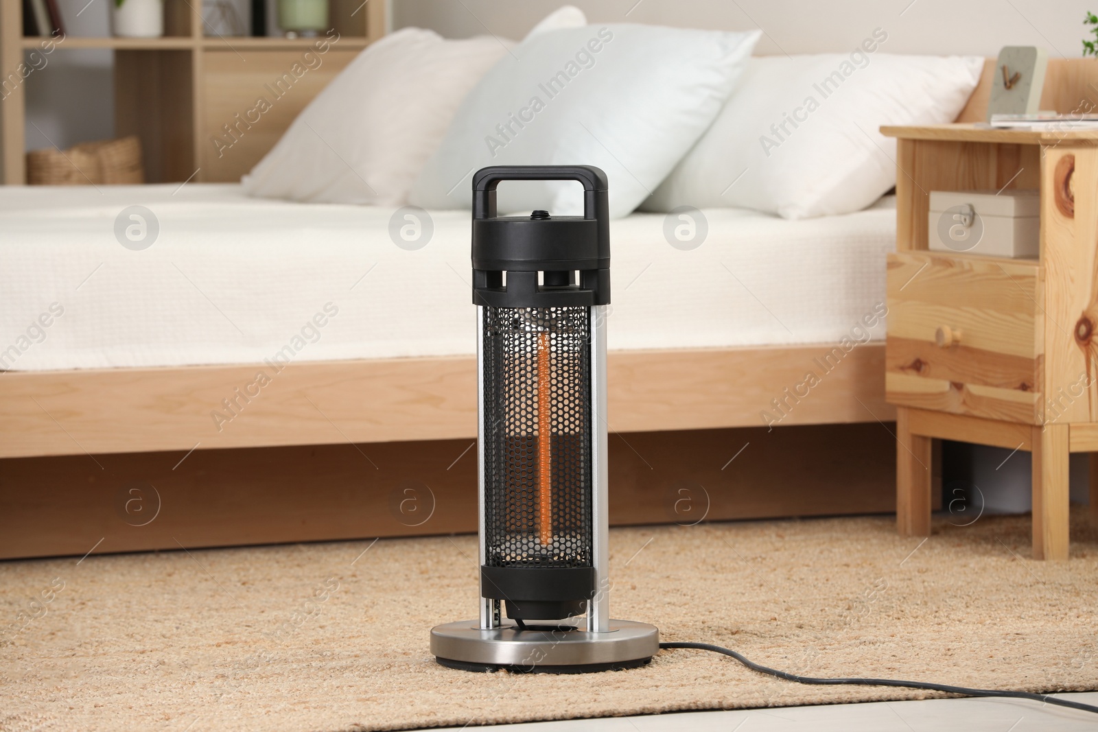 Photo of Modern infrared heater on carpet in cozy room