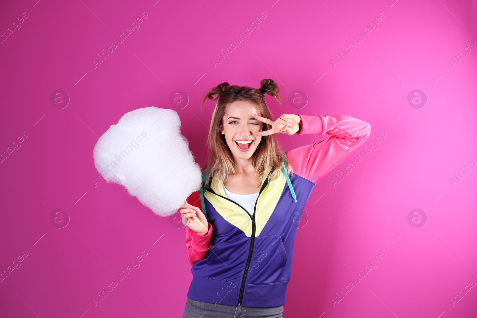 Photo of Young pretty woman with cotton candy on colorful background