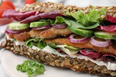 Photo of Delicious sandwich with schnitzel on white plate, closeup
