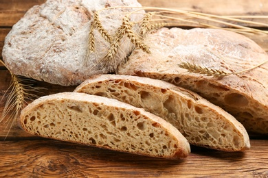 Tasty freshly baked bread on wooden table