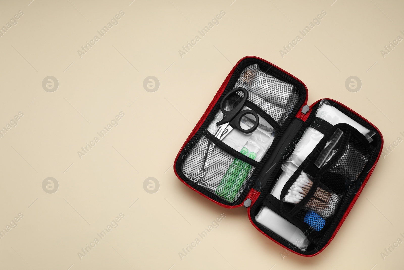 Photo of Open first aid kit on beige background, top view. Space for text