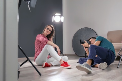 Photo of Beautiful young model posing for professional photographer in studio