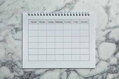Photo of Blank calendar on marble background, top view