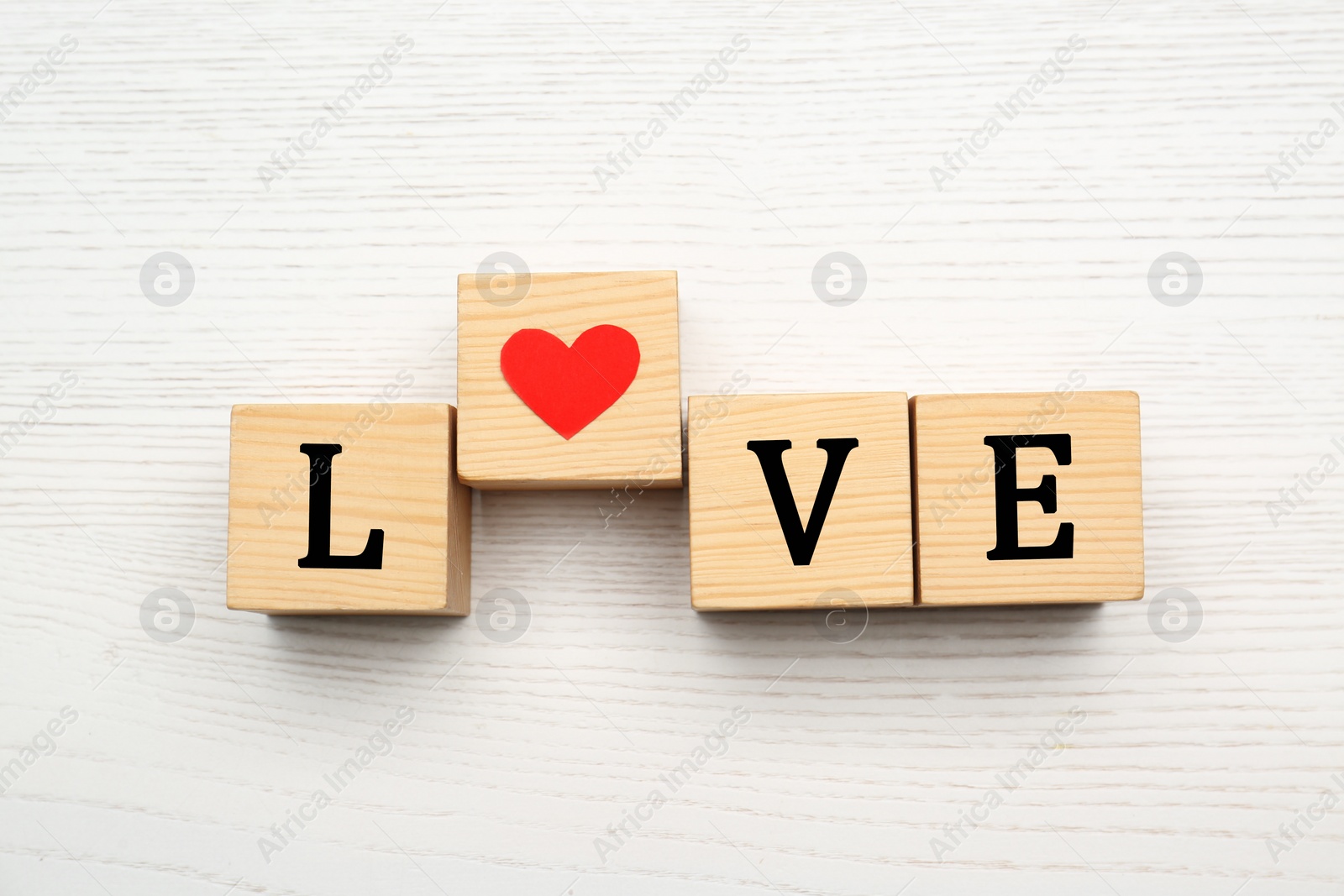 Photo of Cubes with word LOVE on white wooden background, flat lay