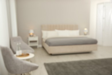 Photo of Blurred view of beautiful hotel room interior with double bed