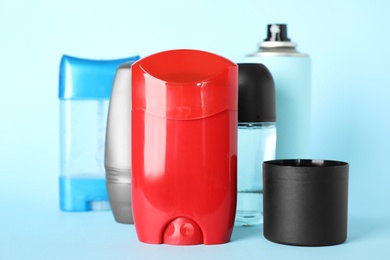 Photo of Set of different male deodorants on light blue background