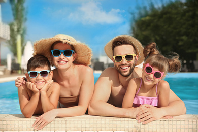 Photo of Happy family in swimming pool on sunny day