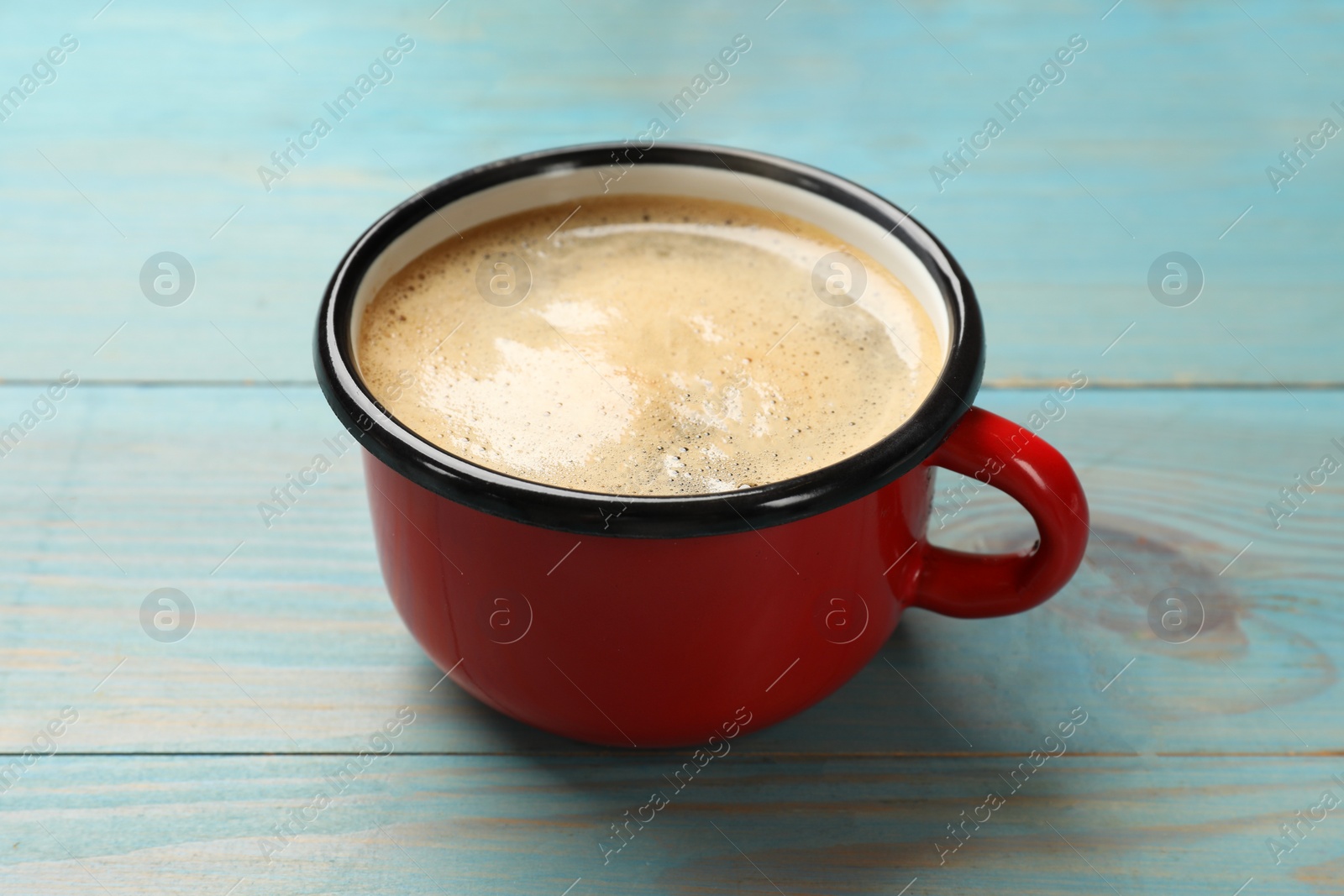 Photo of Cup of aromatic coffee on light blue wooden table, closeup