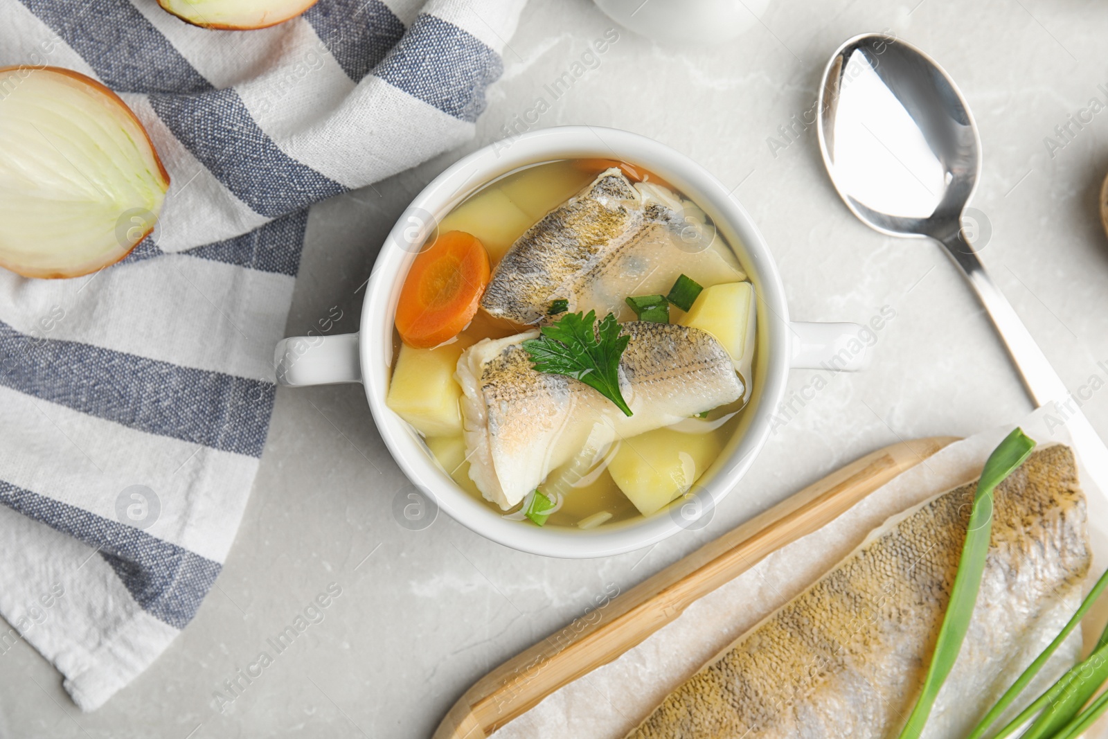 Photo of Delicious fish soup served on light table, flat lay