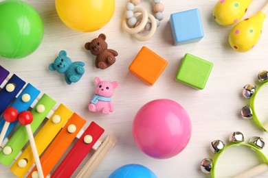 Photo of Baby song concept. Wooden tambourines , xylophone and toys on table, flat lay