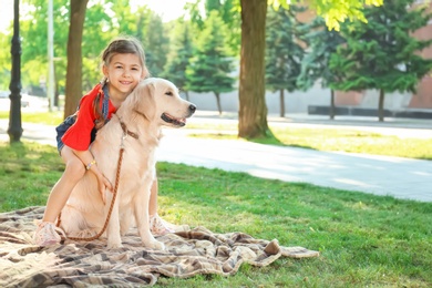 Photo of Cute little child with his pet in green park