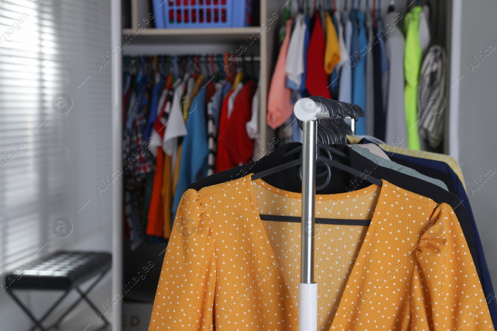 Photo of Rack with stylish women's clothes in dressing room, closeup