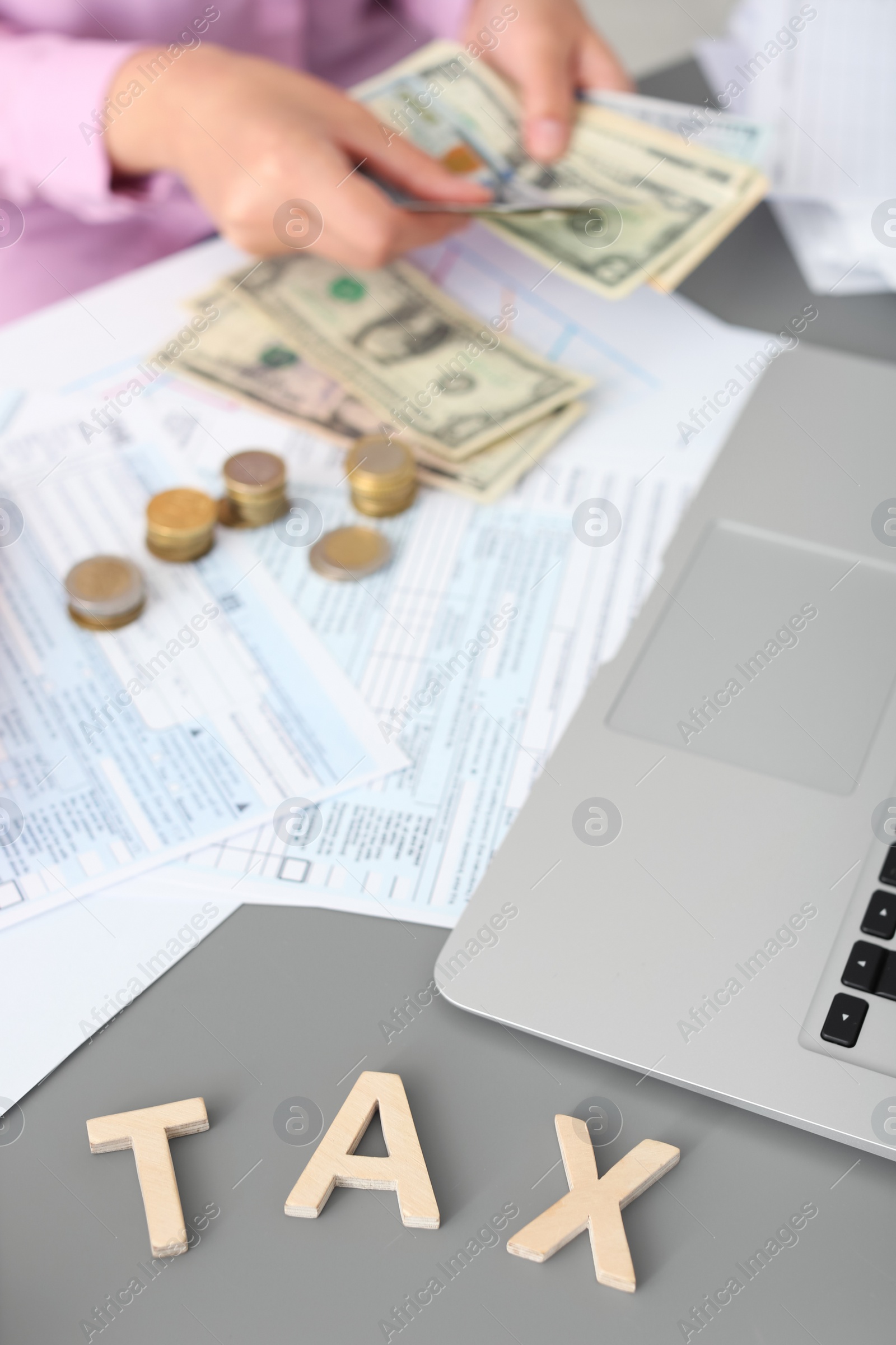 Photo of Young female calculating taxes at table, closeup