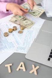 Photo of Young female calculating taxes at table, closeup